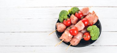 Domates ve sebzeler çiğ tavuk şiş. Kebap. Ahşap bir arka plan üzerinde. Üstten görünüm. Kopya alanı.