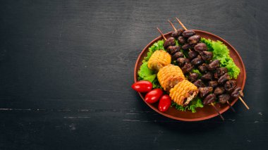 Şiş tavuk kalpler, Mısır ve taze sebze. Ahşap bir arka plan üzerinde. Üstten görünüm. Ücretsiz kopya alanı.