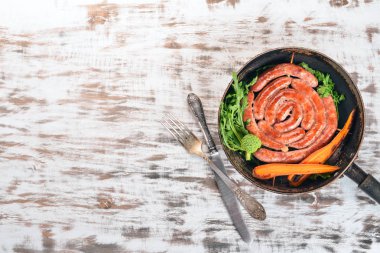 Baharat ile bir tavada kızarmış tavuk sosis. Ahşap bir arka plan üzerinde. Üstten görünüm. Kopya alanı.