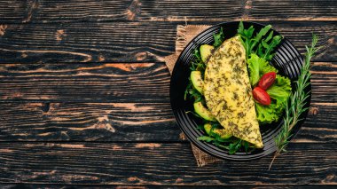 Omlet sebze ve avokado. Kızarmış yumurta. Ahşap bir arka plan üzerinde. Üstten görünüm. Ücretsiz kopya alanı.