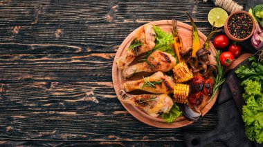 Baharatlar ve sebzeler ile pişmiş tavuk budu. Ahşap bir arka plan üzerinde. Üstten görünüm. Kopya alanı.