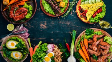 Gıda. Avokado yemekleri, tavuk kanadı, omlet ve barbekü. Ahşap bir arka plan üzerinde. Üstten görünüm. Kopya alanı.