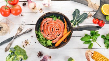 Baharat ile bir tavada kızarmış tavuk sosis. Ahşap bir arka plan üzerinde. Üstten görünüm. Kopya alanı.