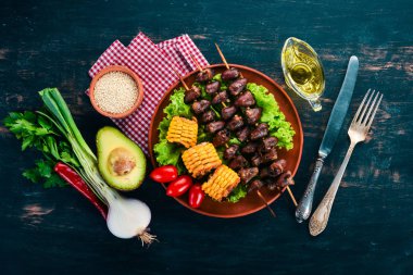 Şiş tavuk kalpler, Mısır ve taze sebze. Ahşap bir arka plan üzerinde. Üstten görünüm. Ücretsiz kopya alanı.