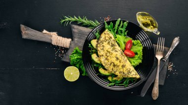 Omlet sebze ve avokado. Kızarmış yumurta. Ahşap bir arka plan üzerinde. Üstten görünüm. Ücretsiz kopya alanı.