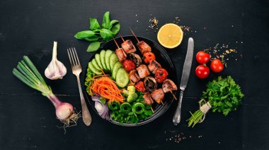 Bir tabak taze sebze ile pişmiş dana eti şiş kebap. Ahşap bir arka plan üzerinde. Üstten görünüm. Kopya alanı.