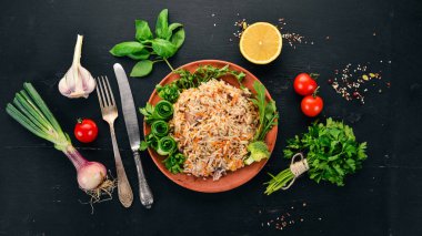 Et ve sebze bir plaka üzerinde plov pilav. Özbek mutfağı. Ahşap bir arka plan üzerinde. Üstten görünüm. Kopya alanı.