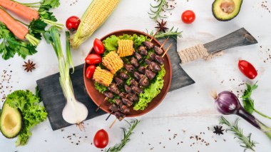 Şiş tavuk kalpler, Mısır ve taze sebze. Ahşap bir arka plan üzerinde. Üstten görünüm. Ücretsiz kopya alanı.