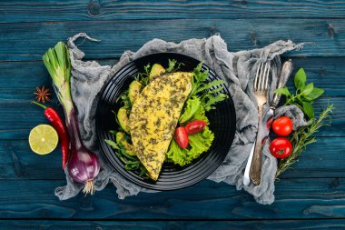 Omlet sebze ve avokado. Kızarmış yumurta. Ahşap bir arka plan üzerinde. Üstten görünüm. Ücretsiz kopya alanı.