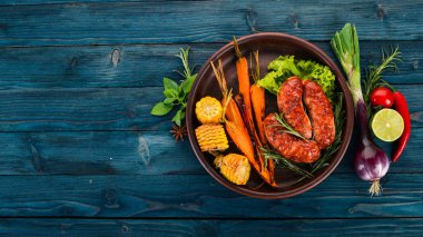 Izgara sosis. Pişmiş Mısır ve patates gibiydik. Ahşap bir arka plan üzerinde. Üstten görünüm. Kopya alanı.