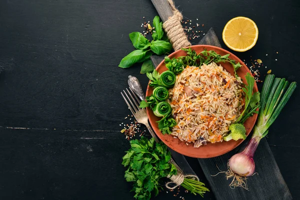 Et ve sebze bir plaka üzerinde plov pilav. Özbek mutfağı. Ahşap bir arka plan üzerinde. Üstten görünüm. Kopya alanı.