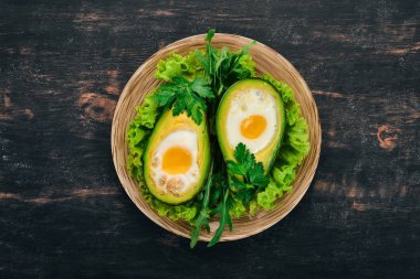 Yumurta ile pişmiş avokado. Sağlıklı gıda. Ahşap bir arka plan üzerinde. Üstten görünüm. Kopya alanı.