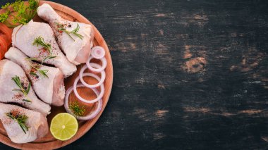 Baharatlar ve sebzeler çiğ tavuk budu. Ahşap bir arka plan üzerinde. Üstten görünüm. Kopya alanı.