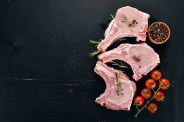 Kemik baharatlar ve sebzeler çiğ biftek. Ahşap bir arka plan üzerinde. Üstten görünüm. Kopya alanı.