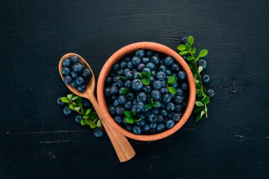 Yaprakları bir ahşap plaka ile yaban mersini. Ahşap bir arka plan üzerinde. Üstten görünüm. Metniniz için boş alan.