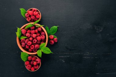 Ahşap bir tabak taze ahududu meyveleri. Ahşap bir arka plan üzerinde. Üstten görünüm. Metniniz için boş alan.