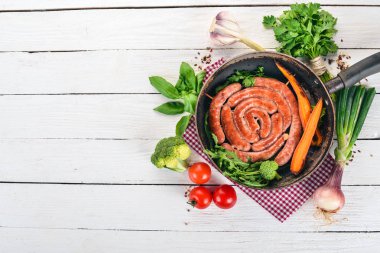 Baharat ile bir tavada kızarmış tavuk sosis. Ahşap bir arka plan üzerinde. Üstten görünüm. Kopya alanı.