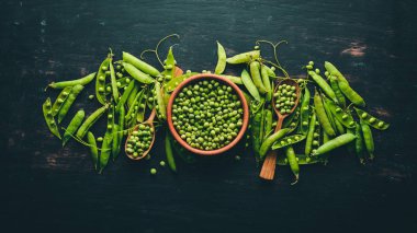 Ahşap bir zemin üzerine yeşil bezelye. Üstten görünüm. Metniniz için boş alan.