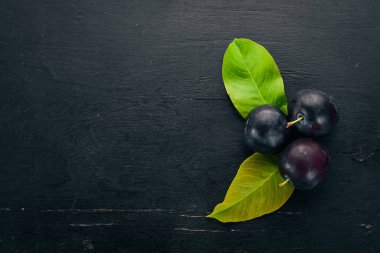 Ahşap arka plan üzerinde taze erik. Üstten görünüm. Metniniz için boş alan.