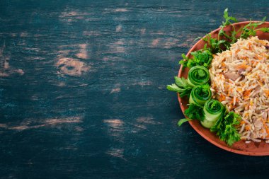 Et ve sebze bir plaka üzerinde plov pilav. Özbek mutfağı. Ahşap bir arka plan üzerinde. Üstten görünüm. Kopya alanı.