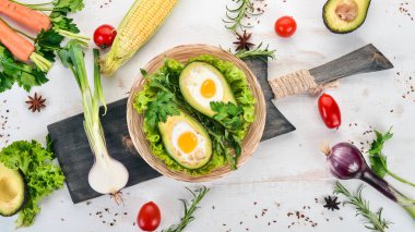 Yumurta ile pişmiş avokado. Sağlıklı gıda. Ahşap bir arka plan üzerinde. Üstten görünüm. Kopya alanı.