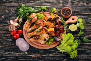 Baharatlar ve sebzeler ile pişmiş tavuk budu. Ahşap bir arka plan üzerinde. Üstten görünüm. Kopya alanı.