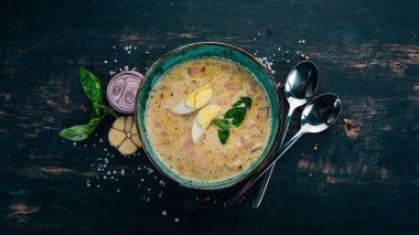 Pastırma, tavuk yumurta, sebze ve fesleğen ile krem çorbası. Ahşap bir masaya. Üstten görünüm. Kopya alanı.