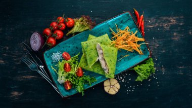 Mantar ve krema soslu ıspanaklı krep. Ahşap bir masaya. Üstten görünüm. Kopya alanı.