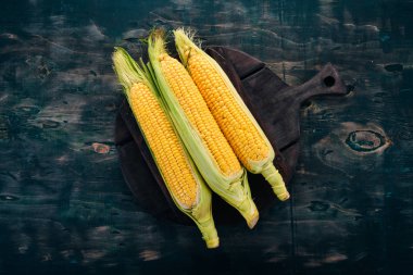 Siyah ahşap bir masa üzerinde taze sarı Mısır. Sebze. Üstten görünüm. Kopya alanı.