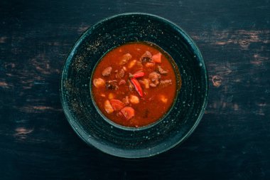 Sığır eti ve biber chervrniy plaka ile domates çorbası. Ahşap bir masaya. Üstten görünüm. Kopya alanı.