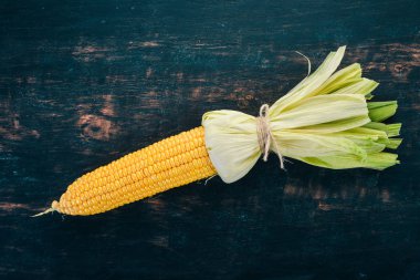 Siyah ahşap bir masa üzerinde taze sarı Mısır. Sebze. Üstten görünüm. Kopya alanı.