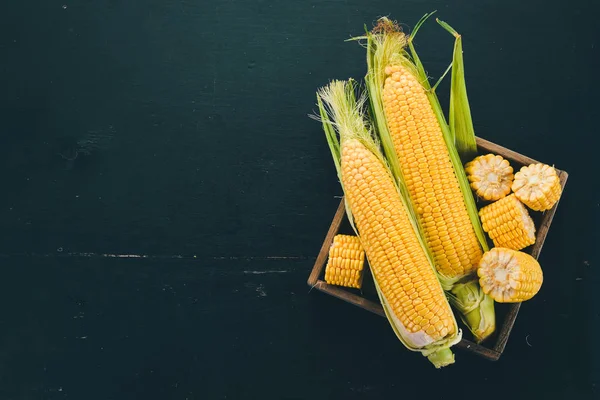 Mısır mezarda. Taze sebze. Siyah ahşap arka plan üzerinde. Üstten görünüm. Kopya alanı.