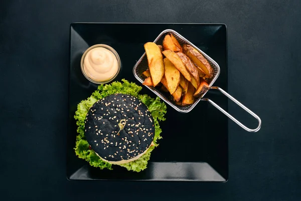 黑汉堡配肉 洋葱和生菜 在一个木质的背景 顶部视图 复制空间 — 图库照片