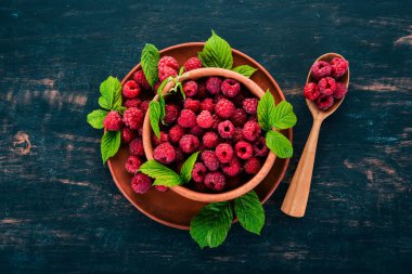 Ahşap bir tabak taze ahududu meyveleri. Ahşap bir arka plan üzerinde. Üstten görünüm. Metniniz için boş alan.