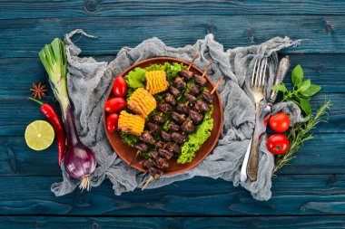 Şiş tavuk kalpler, Mısır ve taze sebze. Ahşap bir arka plan üzerinde. Üstten görünüm. Ücretsiz kopya alanı.