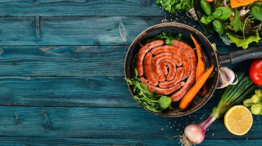 Baharat ile bir tavada kızarmış tavuk sosis. Ahşap bir arka plan üzerinde. Üstten görünüm. Kopya alanı.