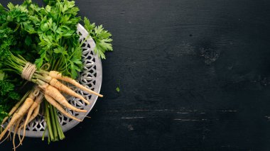 Taze yeşil maydanoz. Kök maydanoz. Ahşap bir arka plan üzerinde. Üstten görünüm. Kopya alanı.