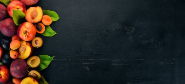 Taze meyve. Kayısı, şeftali, Erik, nektarin. Ahşap bir arka plan üzerinde. Üstten görünüm. Metniniz için boş alan.
