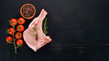 Kemik baharatlar ve sebzeler çiğ biftek. Ahşap bir arka plan üzerinde. Üstten görünüm. Kopya alanı.