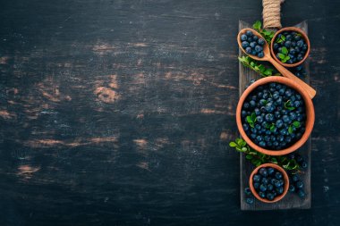Yaprakları bir ahşap plaka ile yaban mersini. Ahşap bir arka plan üzerinde. Üstten görünüm. Metniniz için boş alan.