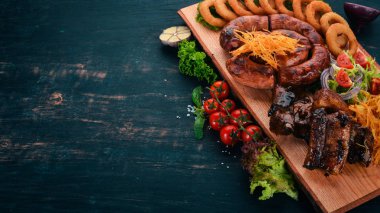 Izgara et gemide. Sosis, kaburga ve taze sebze. Ahşap bir masaya. Üstten görünüm. Kopya alanı.