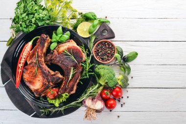 Baharatlar ve sebzeler ile kemik üzerinde pişmiş biftek. Ahşap bir arka plan üzerinde. Üstten görünüm. Kopya alanı.