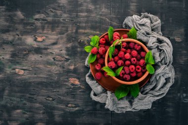 Ahşap bir tabak taze ahududu meyveleri. Ahşap bir arka plan üzerinde. Üstten görünüm. Metniniz için boş alan.