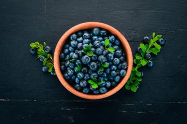 Yaprakları bir ahşap plaka ile yaban mersini. Ahşap bir arka plan üzerinde. Üstten görünüm. Metniniz için boş alan.