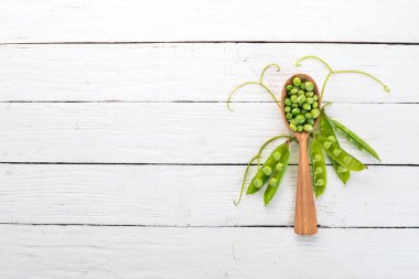 Ahşap bir zemin üzerine yeşil bezelye. Üstten görünüm. Metniniz için boş alan.