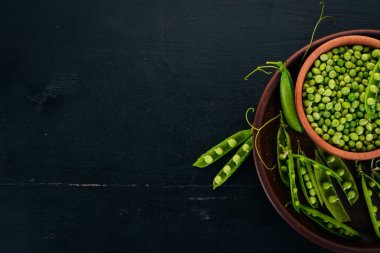 Yeşil bezelye bir ahşap plaka. Ahşap bir arka plan üzerinde. Üstten görünüm. Metniniz için boş alan.