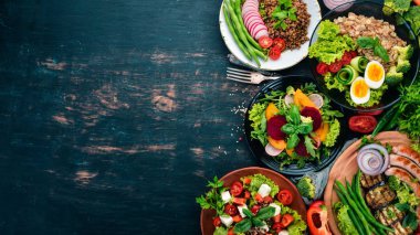 Gıda kümesi. Tavuk göğsü, sosis, patlıcan, domates, taze sebze ızgara. Siyah ahşap bir masa üzerinde. Üstten görünüm. Metin için boş alan.