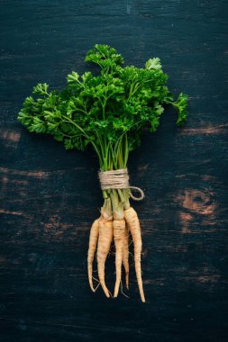 Taze yeşil maydanoz. Kök maydanoz. Ahşap bir arka plan üzerinde. Üstten görünüm. Kopya alanı.