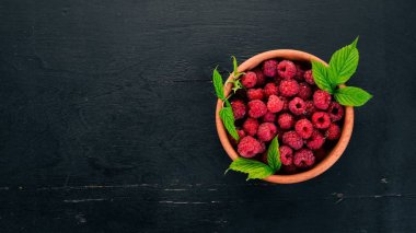 Ahşap bir tabak taze ahududu meyveleri. Ahşap bir arka plan üzerinde. Üstten görünüm. Metniniz için boş alan.