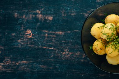 Haşlanmış patates dereotu bir kase ile. Ahşap bir arka plan üzerinde. Üstten görünüm. Kopya alanı.